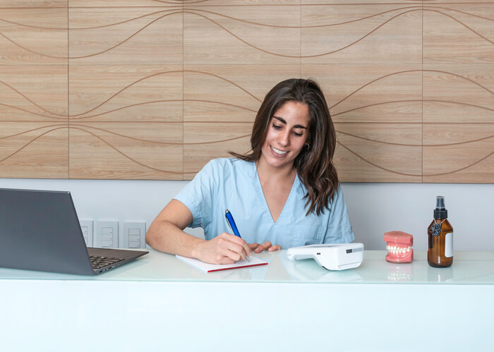 A female dental assistant at a dentist's office after dental reception training