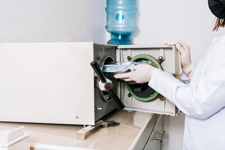 A dental assistant training graduate sterilizing equipment.