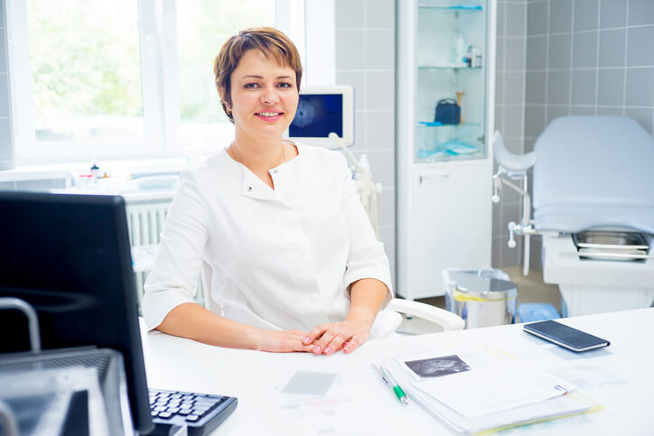 A dental assistant training graduate working at a desk.