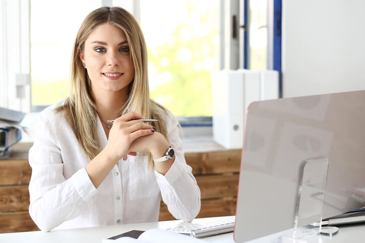 A smiling education assistant working on a laptop after education assistant training