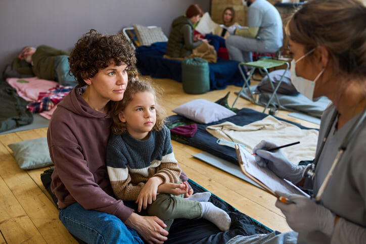 A female support worker interacts with a shelter occupant and her child after mental health worker training.