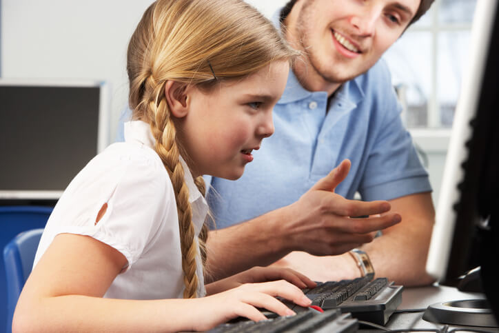 education assistant training grad helping a student as they use a computer