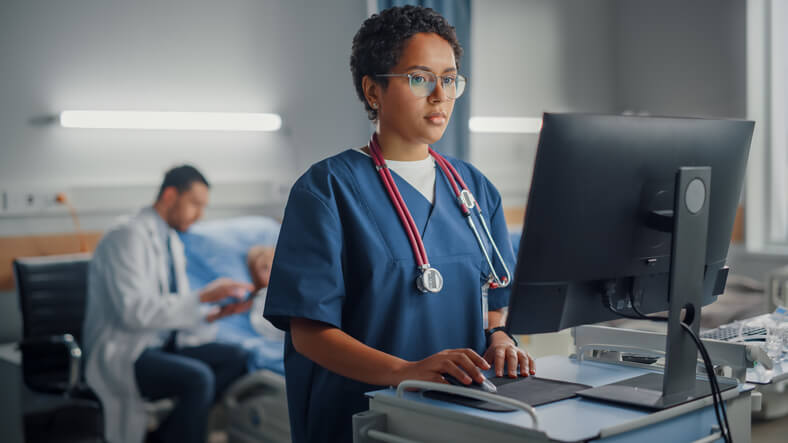 A practical nurse training graduate working on a computer