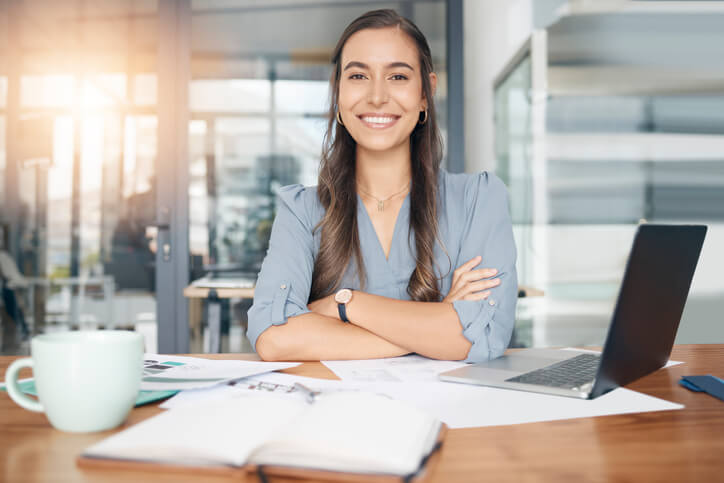 A smiling female education assistant in an office after education assistant training