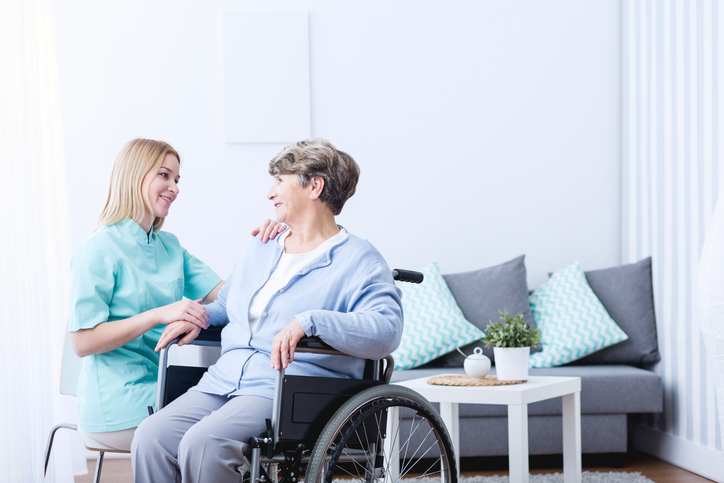 A friendly female healthcare assistant interacting with a female patient after her healthcare assistant training